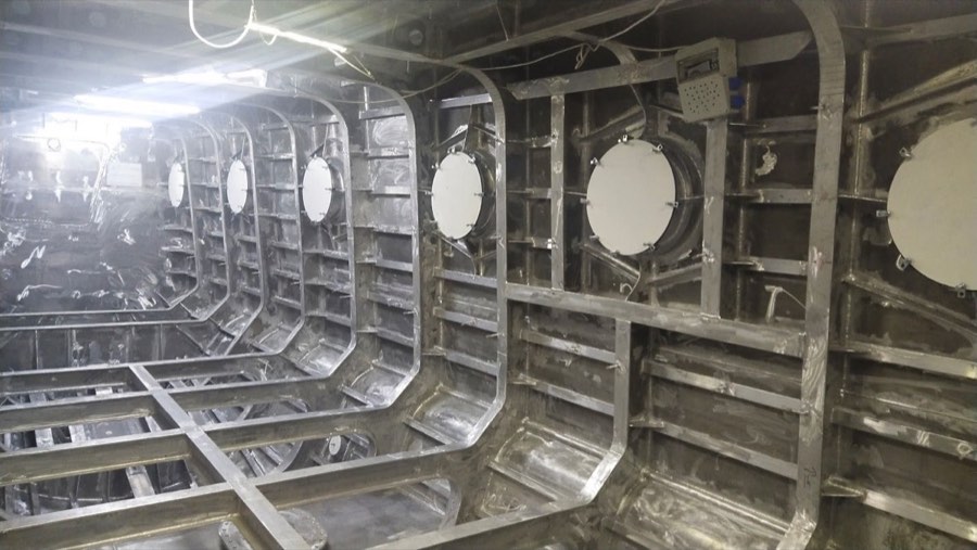 Interior of a welded aluminum hull under construction, showing frames and longitudinals.