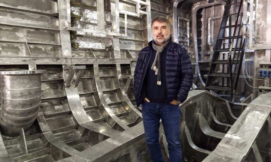 A production manager standing inside a hull section during outfitting.